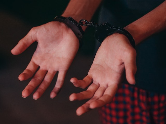 man with palms extended in handcuffs